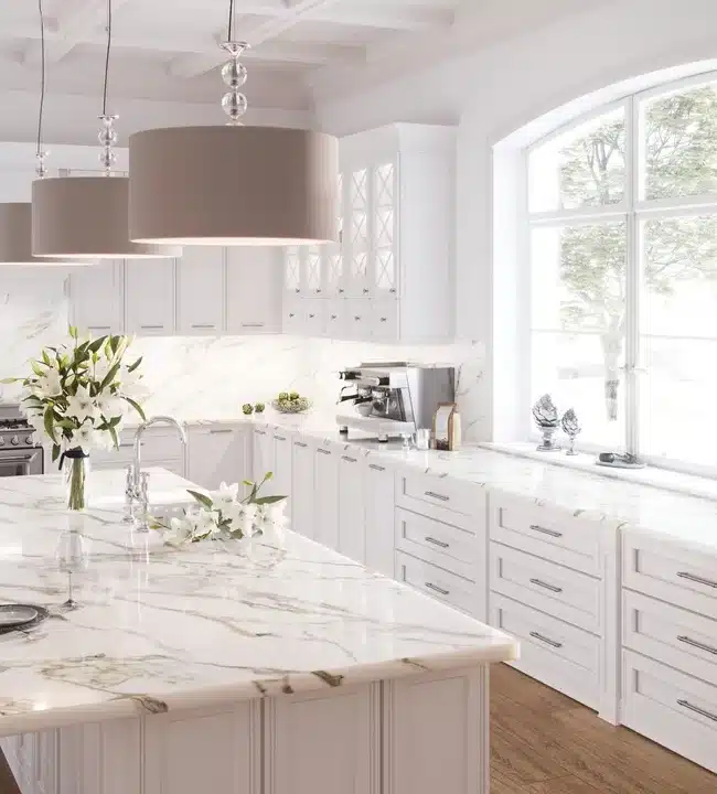 A large white kitchen with marble counter tops.