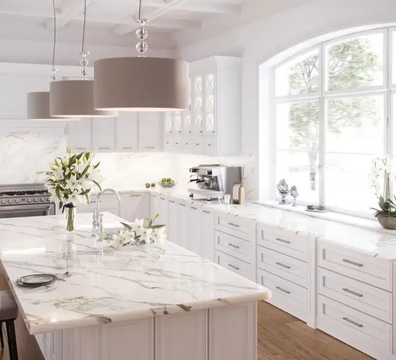 A large white kitchen with marble counter tops.