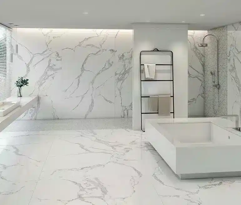 A bathroom with white marble walls and floors.