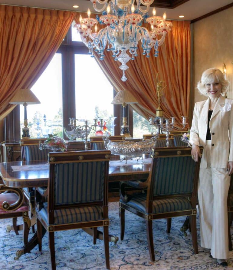 An opulent dining area showcasing beautiful vintage furnishings, artwork, sculptures, and a breathtaking Murano glass chandelier