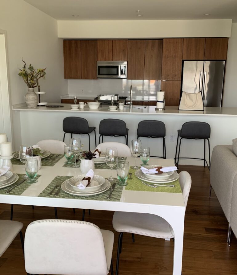 Modern Kitchen with contrasting wood cabinets and modern dining room setting reflecting organic feel to a coastal living