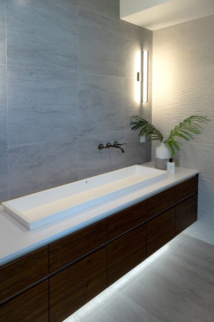 Modern bathroom sink with wooden cabinet and minimalist decor.
