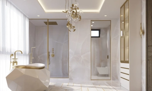 Luxury bathroom with natural marble floors, with a mosaic finish and bronze inlays, add unique and opulent touches. White cabinets with vanity seating elevate the space, while a grand chandelier completes the luxurious ambiance | Karamia Designs