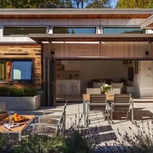 A patio with chairs and tables outside of it