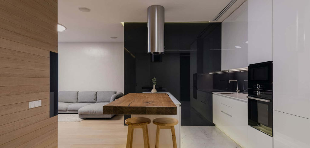 Modern small apartment kitchen and dining room featuring wood-like cabinet doors and a compact dining table. The design maximizes space with a sleek, contemporary look and functional layout.